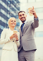 Image showing smiling businessmen with paper cups outdoors