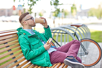 Image showing happy young hipster man with coffee and sandwich