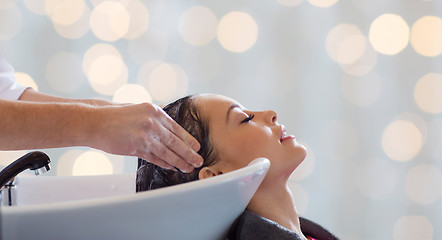 Image showing happy young woman having salon hair wash