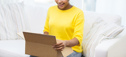 Image showing happy african young woman with parcel box at home