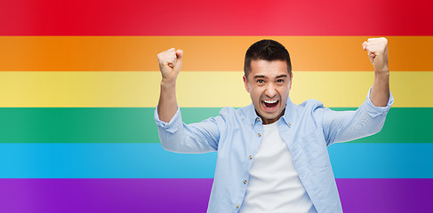 Image showing angry man with raised hands over rainbow flag