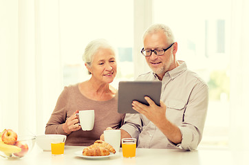 Image showing happy senior couple with tablet pc at home