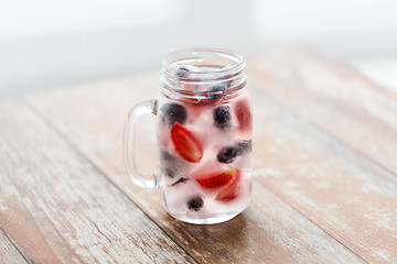 Image showing close up of fruit water in glass mug on table