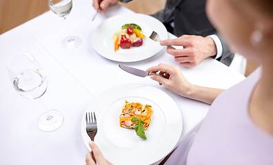 Image showing close up of couple eating appetizers at restaurant