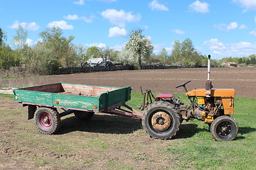 Image showing old tractor with trailer in village