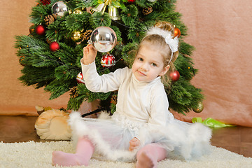 Image showing Three year old girl playing Christmas balls