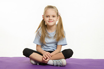 Image showing Six year old girl athlete sitting on a rug