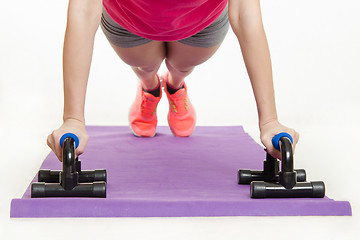 Image showing She performs the bench press with help of stops