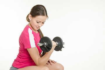 Image showing She shakes dumbbell arm muscles