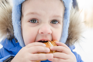 Image showing Girl eating a roll