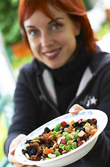 Image showing young laughing red-haired woman offering candied fruits