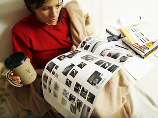 Image showing a young woman is reading a new car booklet