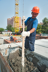 Image showing Worker kneads solution for bricklayers