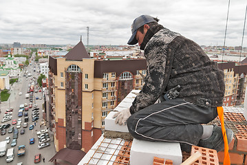 Image showing Bricklayer on construction over street traffic