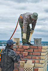 Image showing Bricklayers work on high house construction