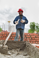 Image showing Builder man works with shovel at construction site