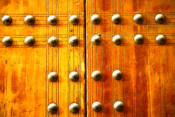 Image showing metal  paint in the     red wood door and rusty  yellow  