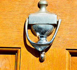 Image showing handle in london antique brown door  rusty  brass nail and light