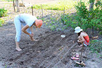Image showing mother and her daughter plant seeding-onion