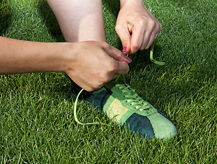 Image showing woman ties laces on sport shoes