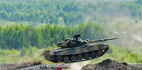 Image showing Shooting tank T-80 jumps through ditch