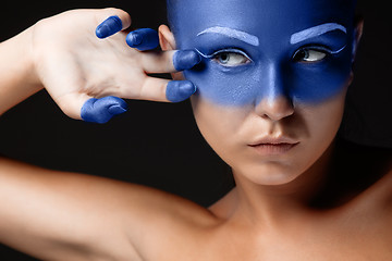 Image showing Portrait of a woman who is posing covered with blue paint