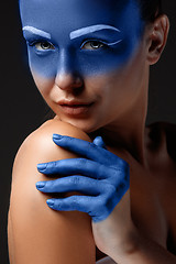 Image showing Portrait of a woman who is posing covered with blue paint