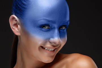 Image showing Portrait of a woman who is posing covered with blue paint