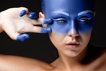 Image showing Portrait of a woman who is posing covered with blue paint