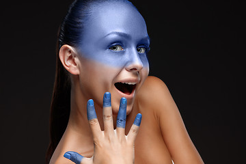 Image showing Portrait of a woman who is posing covered with blue paint