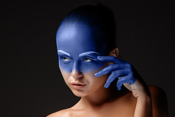 Image showing Portrait of a woman who is posing covered with blue paint