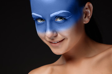 Image showing Portrait of a woman who is posing covered with blue paint