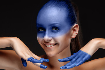 Image showing Portrait of a woman who is posing covered with blue paint