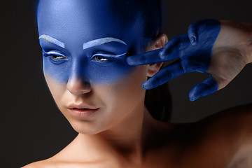 Image showing Portrait of a woman who is posing covered with blue paint