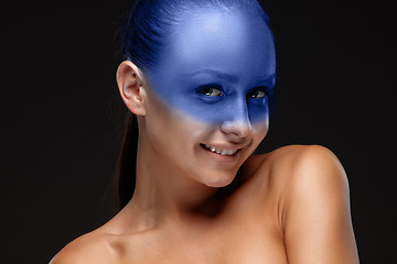 Image showing Portrait of a woman who is posing covered with blue paint