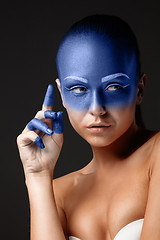 Image showing Portrait of a woman who is posing covered with blue paint