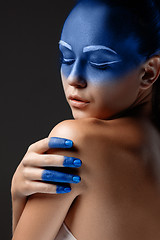 Image showing Portrait of a woman who is posing covered with blue paint