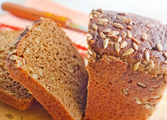 Image showing Fresh bread and knife on the wooden board