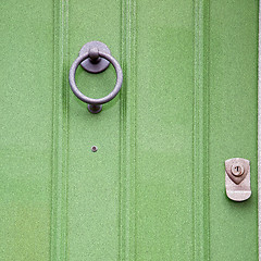 Image showing green  handle in london antique brown door  rusty  brass nail an