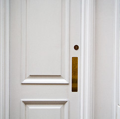 Image showing handle in london antique brown door  rusty  brass nail and light