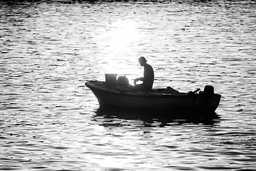 Image showing Man in motor boat at sunset bw