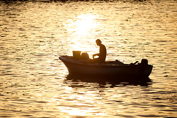 Image showing Man in motor boat at sunset 