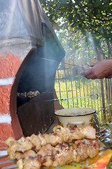 Image showing human hands roasting appetizing barbecue on fire