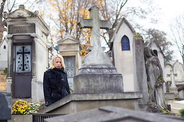 Image showing Solitary woman visiting relatives grave.