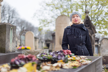 Image showing Solitary woman visiting relatives grave.