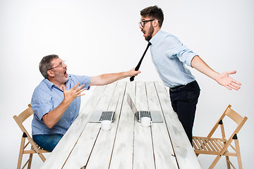 Image showing Business conflict. The two men expressing negativity while one man grabbing the necktie of her opponent