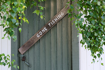 Image showing Gone Fishing sign at on old door