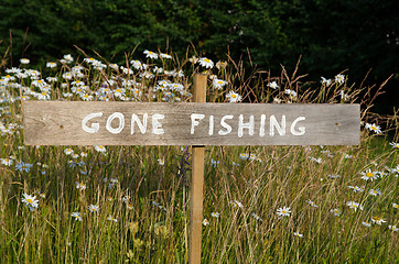 Image showing Gone Fishing sign among flowers