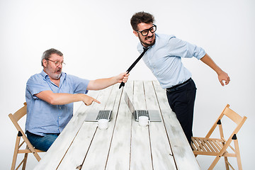 Image showing Business conflict. The two men expressing negativity while one man grabbing the necktie of her opponent