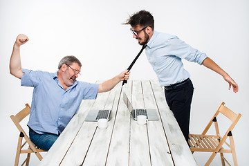 Image showing Business conflict. The two men expressing negativity while one man grabbing the necktie of her opponent